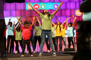 Children in colorful t-shirts and jeans onstage