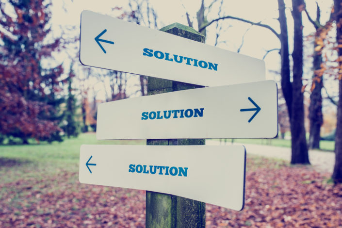 A sign post with signs pointing in multiple direction that all say SOLUTION