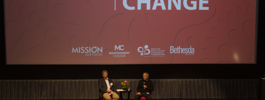 A wide view of a stage with two men in chairs