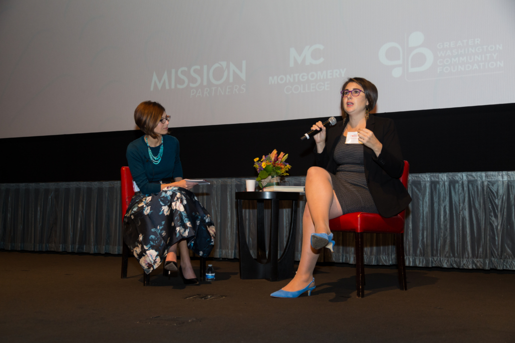 Two women talking on stage