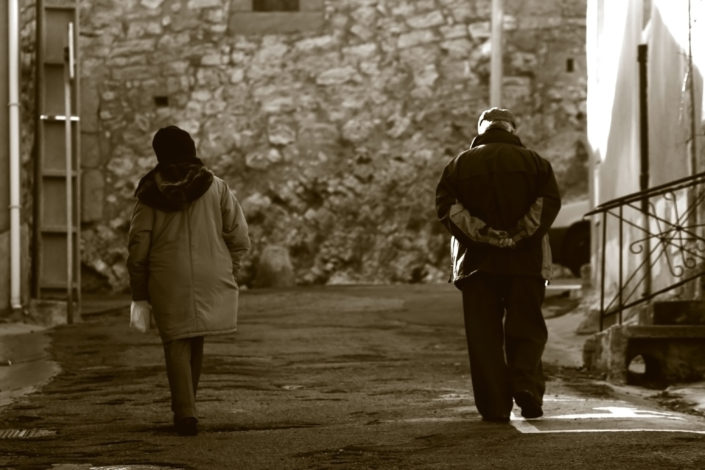 People walking together down a street but separated by a few feet