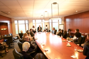 A group of professionals around a conference table listening to a presentation