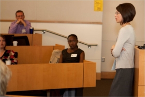 A woman in front of a podium teaching a workshop