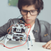 Young boy with glasses working on robotics