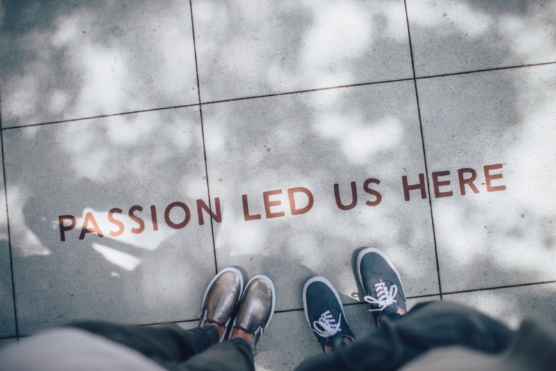 two person standing on gray pavers that say passion led us here