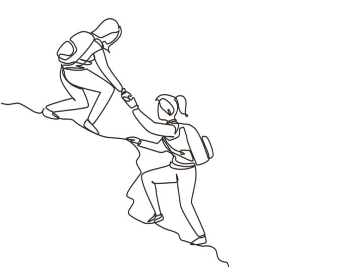 A woman helping another woman up a cliff