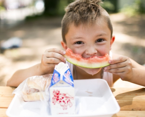 young boy eating a watermelon slice