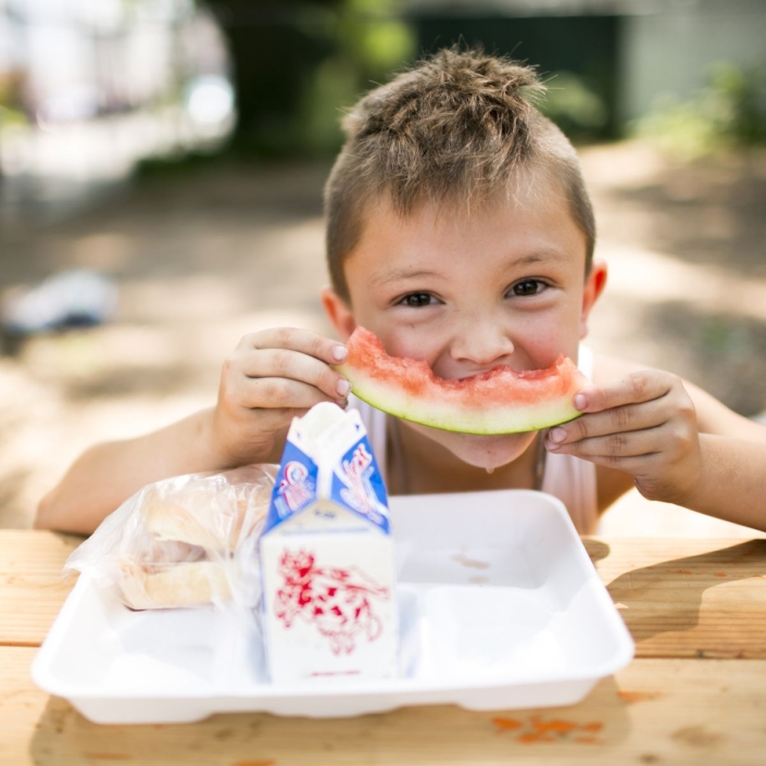 young boy eating a watermelon slice