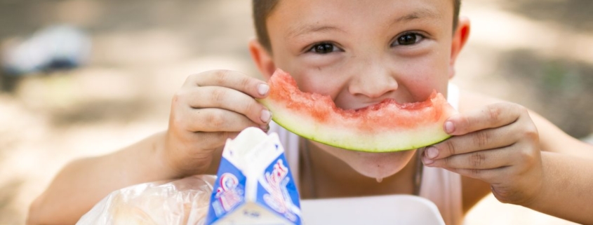 young boy eating a watermelon slice