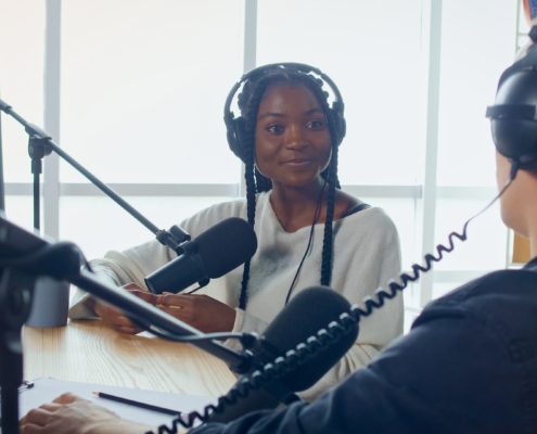 Female Host Talking to a Guest Friend on a Podcast Radio Station in the Studio.