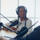 Female Host Talking to a Guest Friend on a Podcast Radio Station in the Studio.