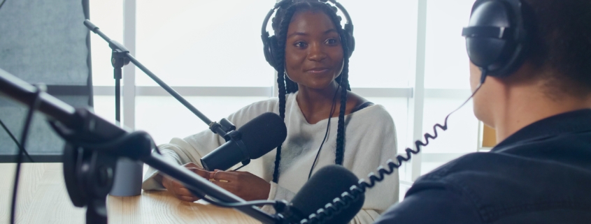 Female Host Talking to a Guest Friend on a Podcast Radio Station in the Studio.