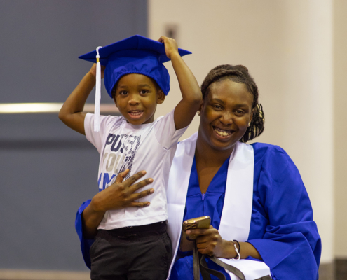 Image of a graduate and a child wearing the hat