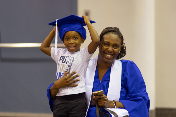 Image of a graduate and a child wearing the hat