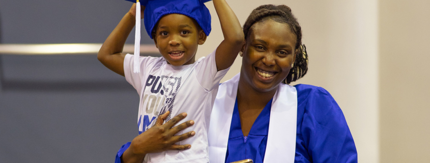 Image of a graduate and a child wearing the hat