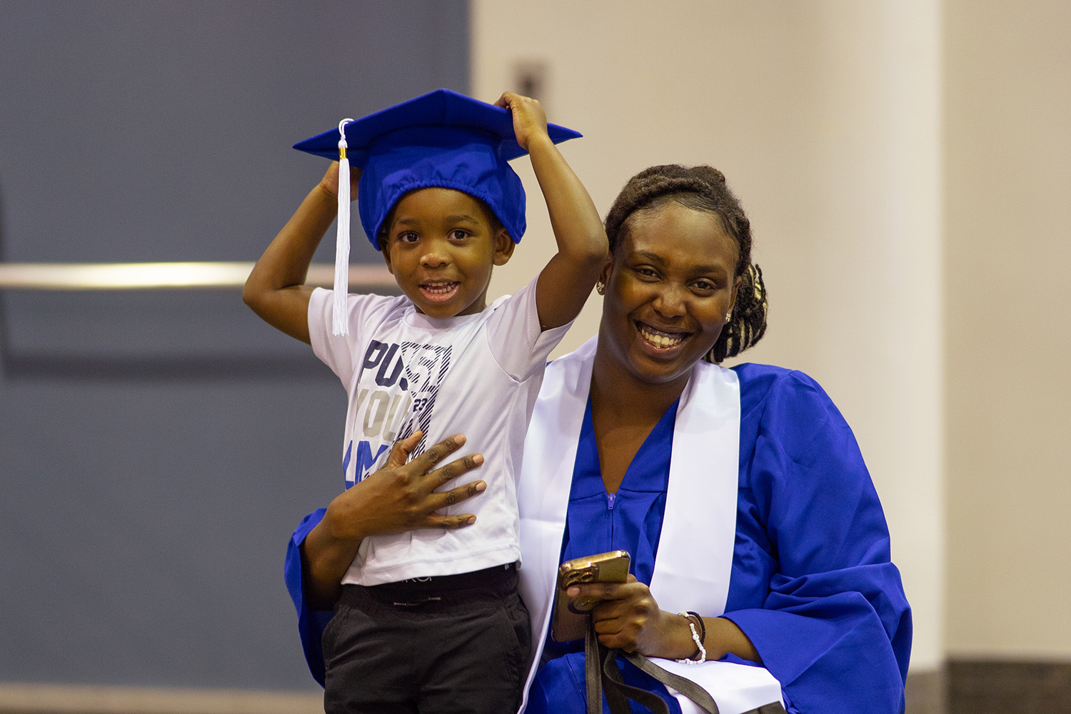 Image of a graduate and a child wearing the hat