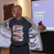 Leanord Burton of CSSP smiling and showing the book images on his shirt while speaking at CARES conference.