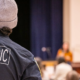 Paramedic watching and listening to a speaker at an event.